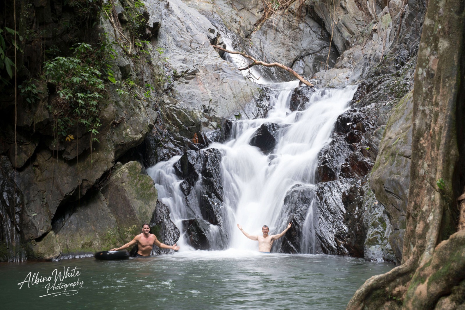 Two people enjoying a rainforest waterfall and swimming pool in Belize; photograph by Albino White